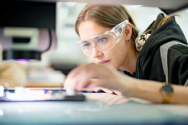 Factory worker wearing safety goggles working in digital factory production