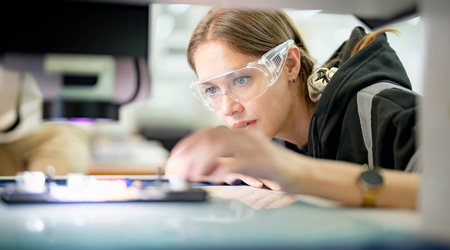 Factory worker wearing safety goggles working in digital factory production