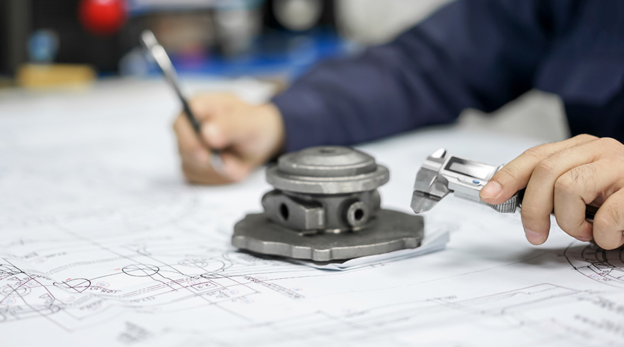 A close up of a factory worker using a caliper